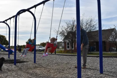 younger children playing on swing set